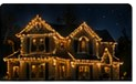 Night house photo with warm-white elegant roofline lighting.