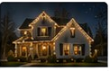 Night house photo showing wide full-property holiday-light treatment.