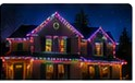 Night house photo with multicolored purple, blue, and warm holiday lights.