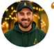 Circular headshot of the testimonial customer wearing a cap and dark shirt.